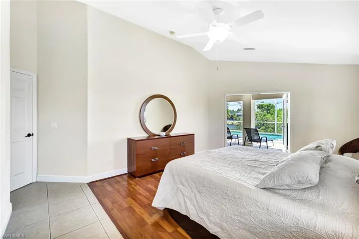 Bedroom with access to outside, light tile patterned floors, baseboards, high vaulted ceiling, and a ceiling fan