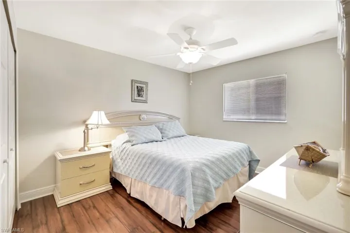 Bedroom with baseboards, dark wood-style floors, and a ceiling fan