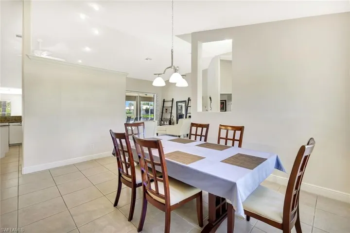 Dining space with light tile patterned floors, baseboards, and a chandelier