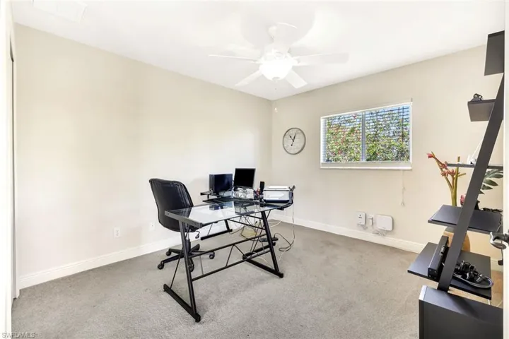Office area with a ceiling fan, carpet, and baseboards