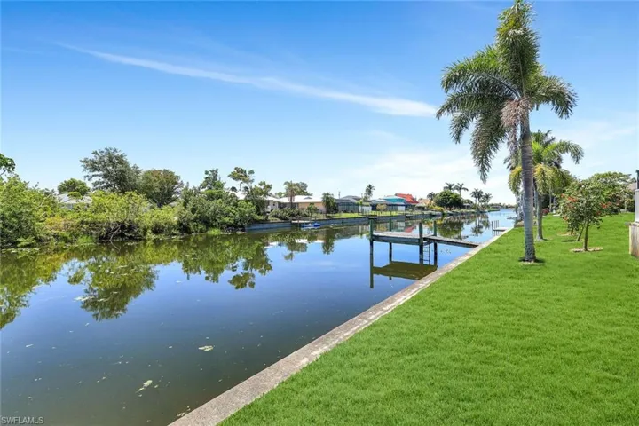 Dock area with a lawn and a water view