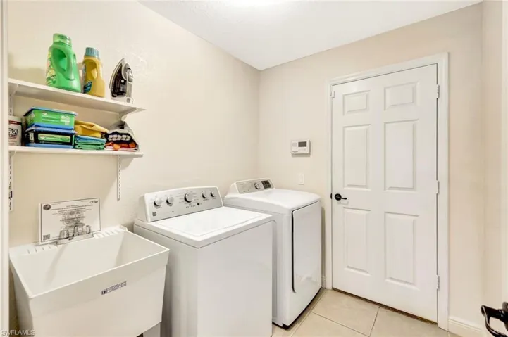 Laundry area featuring independent washer and dryer and light tile patterned flooring