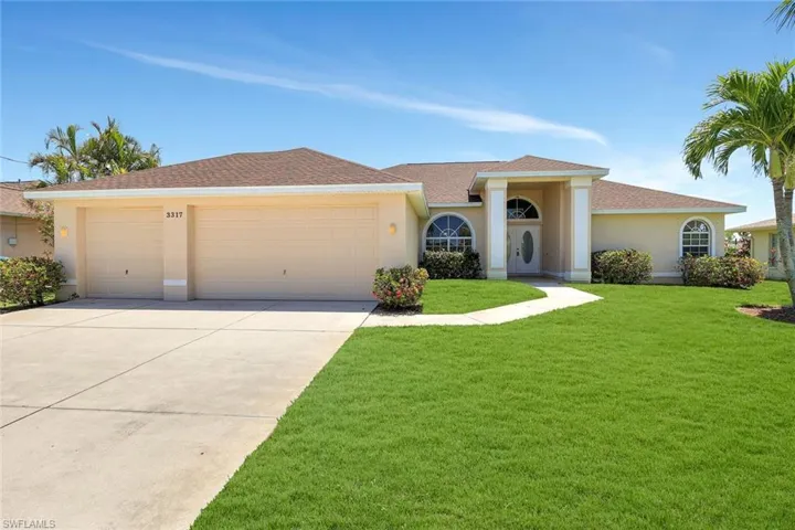 View of front of property featuring a garage, stucco siding, driveway, and a front yard