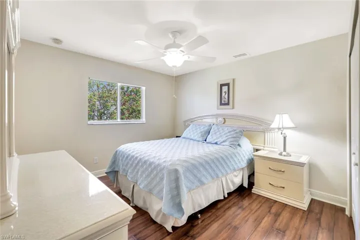 Bedroom featuring baseboards, dark wood finished floors, and ceiling fan