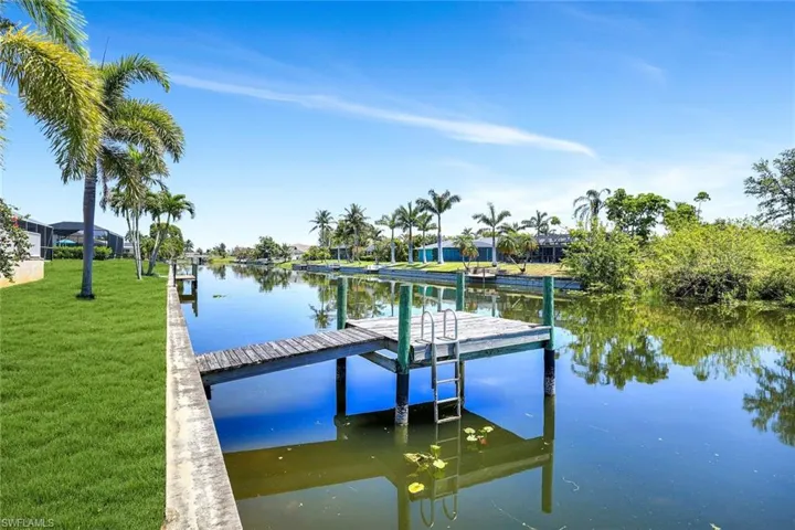 Dock with a water view and a lawn