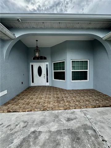 View of exterior entry featuring a patio area and stucco siding