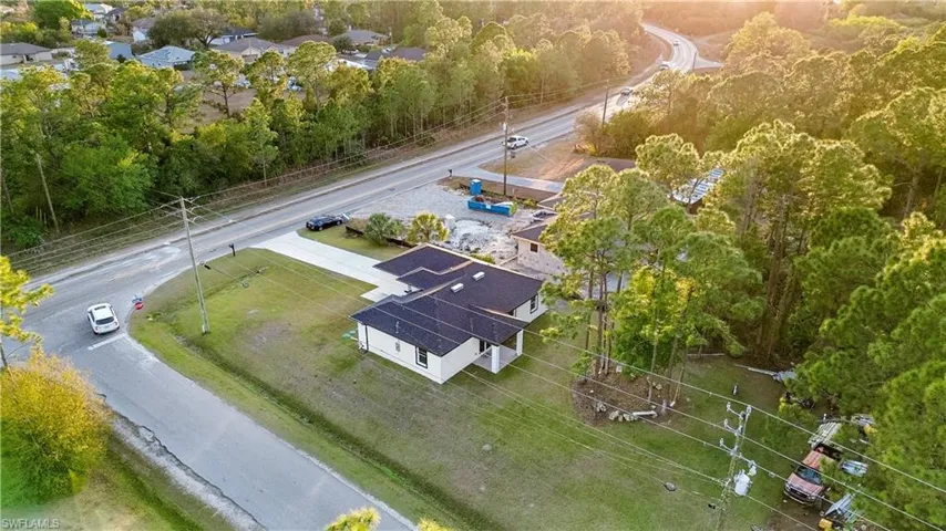 Aerial view of property and surrounding area featuring a tree filled landscape