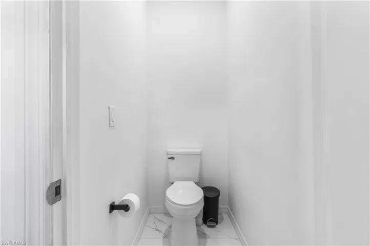 Bathroom with toilet and marble look tiles