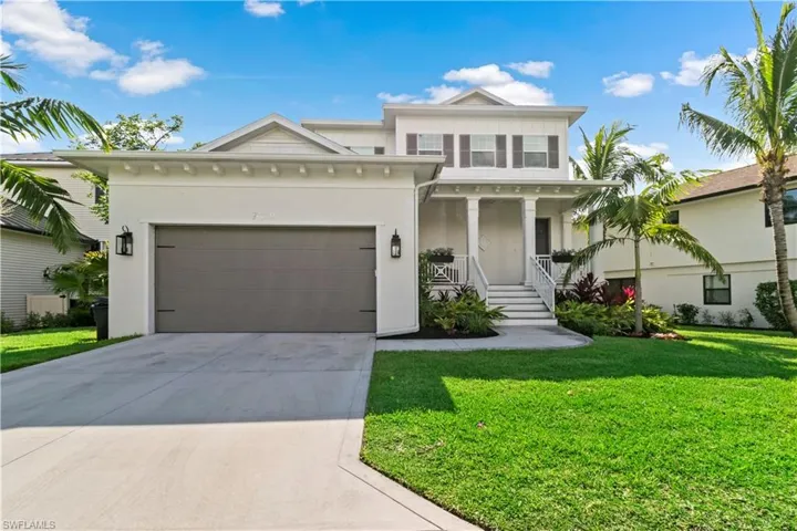View of front facade with a garage, a porch, and a front yard