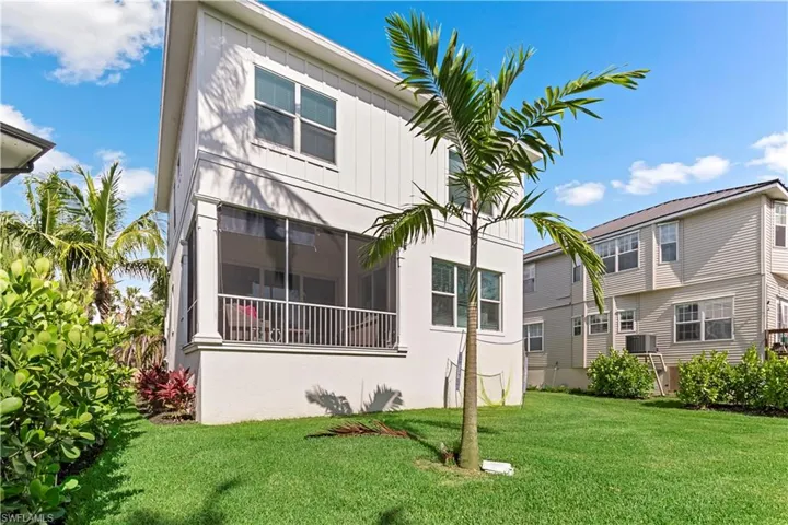 Rear view of property featuring a yard and a sunroom