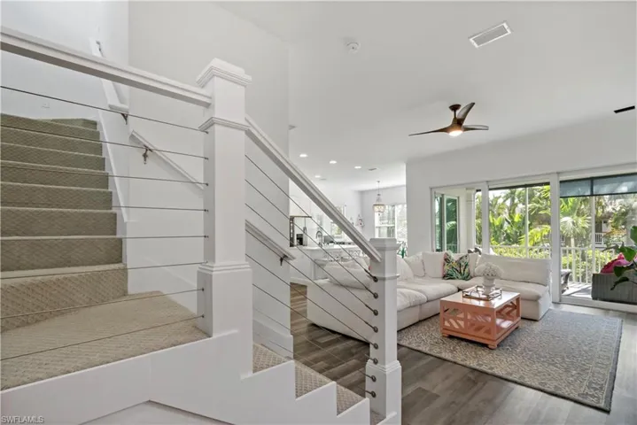 Stairs featuring ceiling fan and wood-type flooring