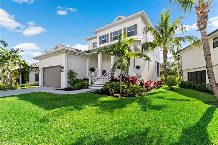 View of front of property with a garage and a front lawn