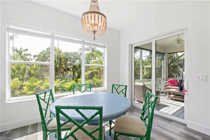 Dining area featuring ceiling fan with notable chandelier and hardwood / wood-style flooring