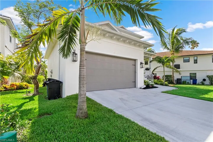 View of front facade featuring a front lawn and a garage