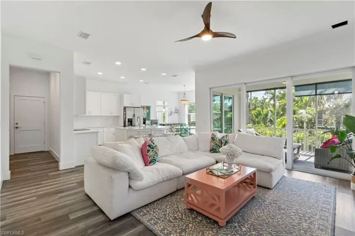 Living room with ceiling fan and dark hardwood / wood-style floors