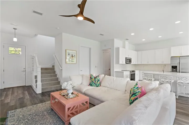 Living room featuring dark wood-type flooring and ceiling fan