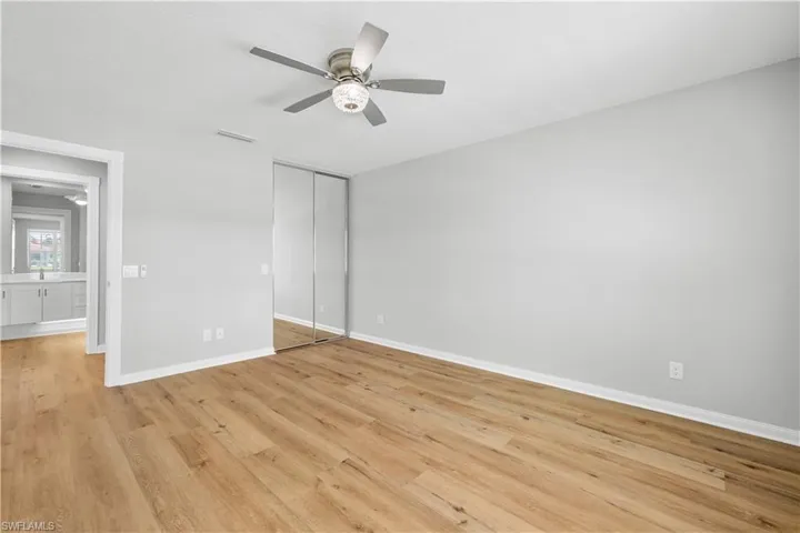 Unfurnished bedroom featuring light wood-style floors, baseboards, a closet, and ceiling fan