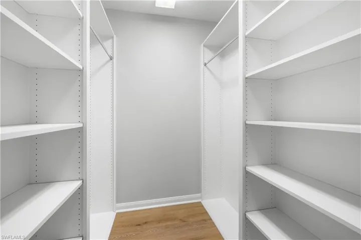 Spacious walk in closet with built in custom shelving