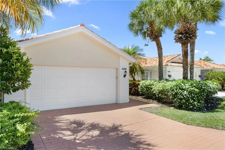Villa style home featuring stucco siding, decorative driveway, and a garage