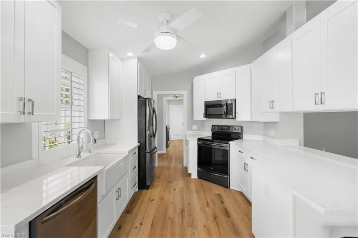 Kitchen featuring stainless steel appliances, light wood-type flooring, white cabinetry, a ceiling fan, and recessed lighting