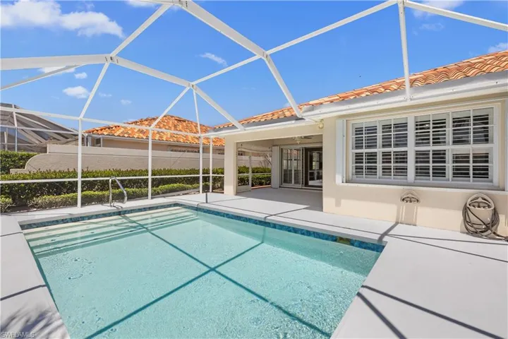 Outdoor pool featuring a patio and glass enclosure