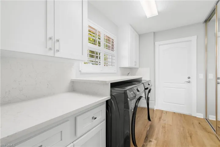 Washroom with cabinet space, washer and dryer, and pantry