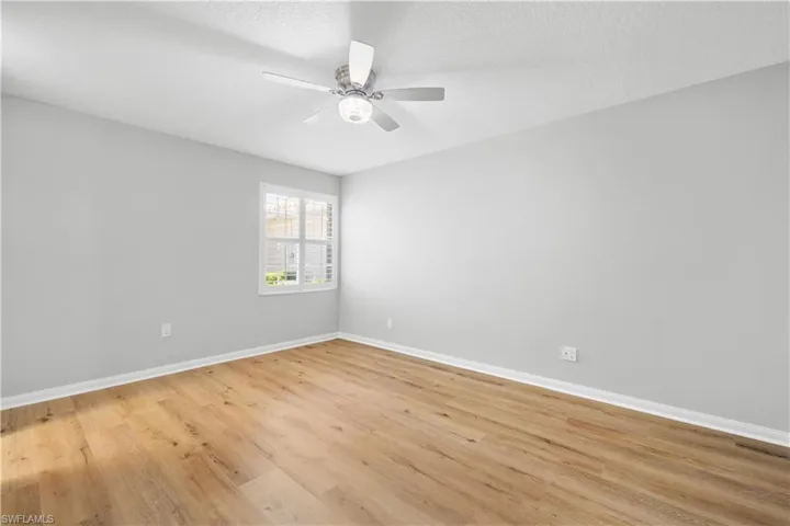 Spare room with ceiling fan, baseboards, and light wood-type flooring
