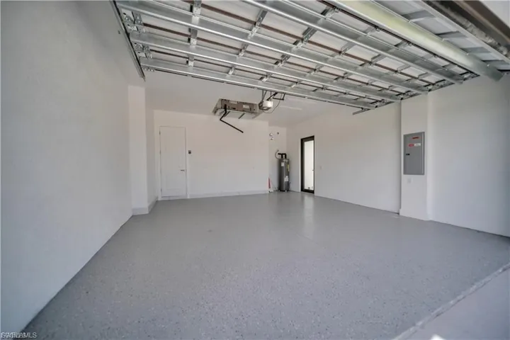 Garage featuring electric panel and electric water heater