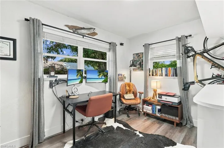 Multi-window room featuring wood-finish flooring, white walls, and dual window sets