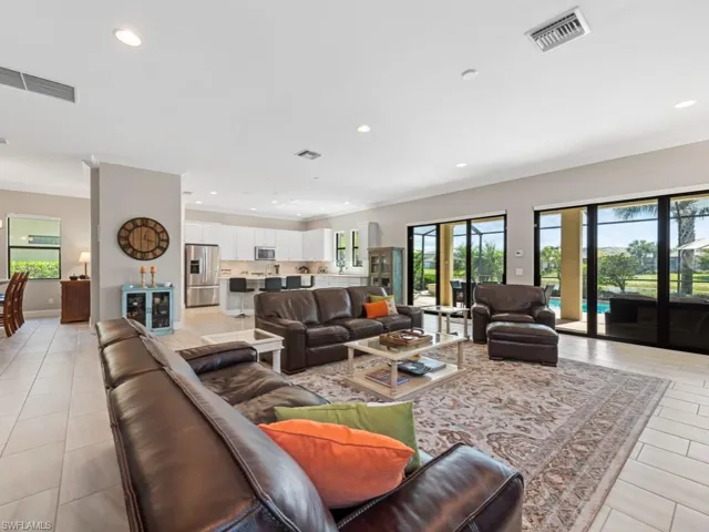 Living area with ornamental molding, visible vents, and recessed lighting