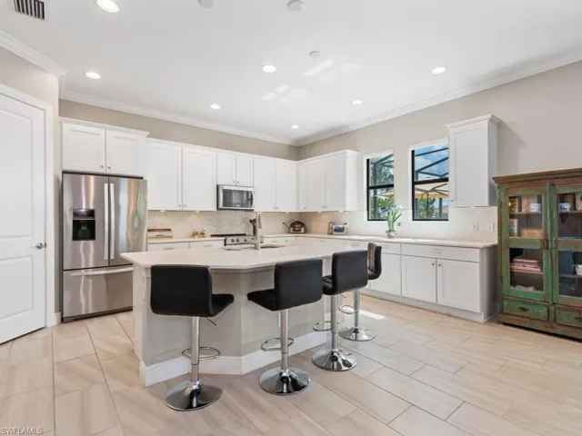 Kitchen with white cabinetry, stainless steel appliances, and light countertops
