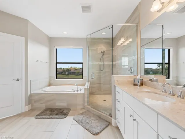 Full bath featuring a garden tub, a stall shower, vanity, and visible vents