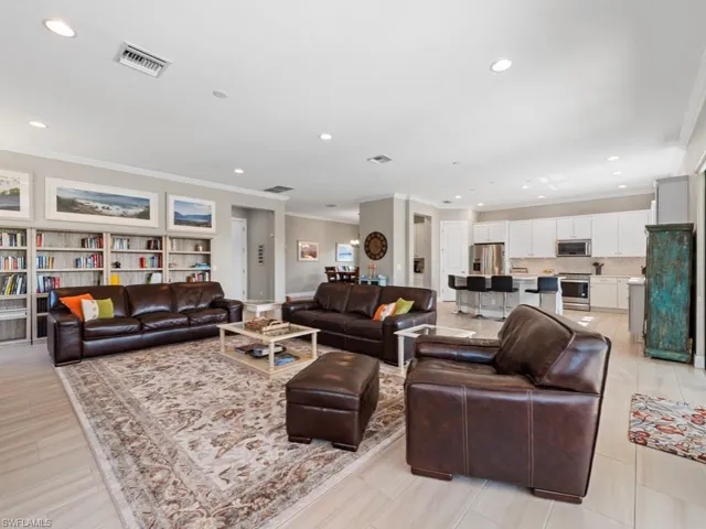 Living room featuring visible vents, crown molding, and recessed lighting