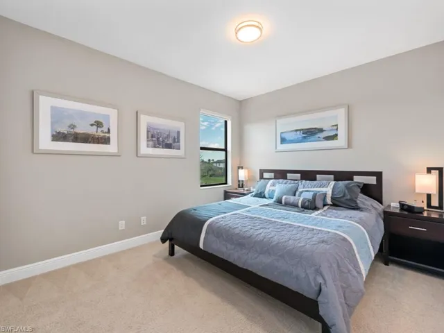 Bedroom featuring light carpet and baseboards