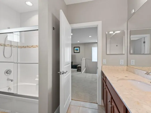Bathroom with recessed lighting, shower / bath combination with glass door, vanity, and tile patterned floors