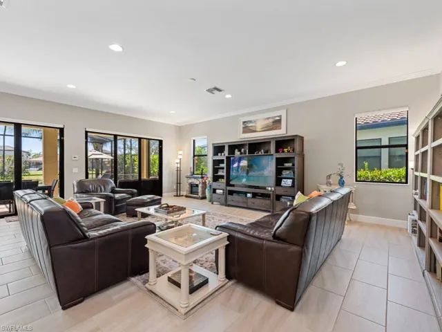 Living area with light tile patterned floors, recessed lighting, visible vents, baseboards, and ornamental molding