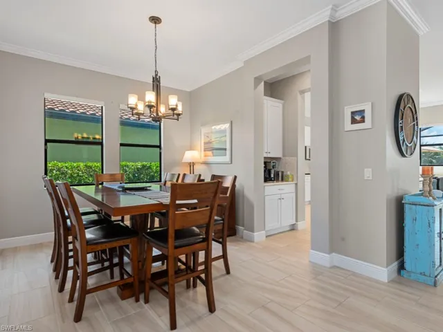 Dining room with a chandelier, crown molding, and a healthy amount of sunlight