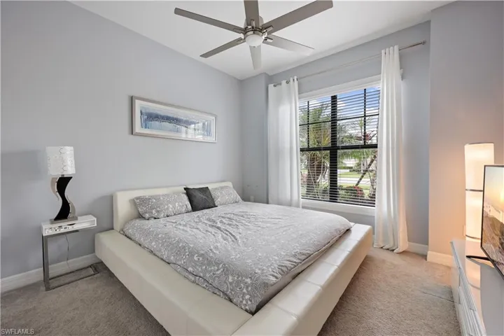 Bedroom with ceiling fan and light colored carpet
