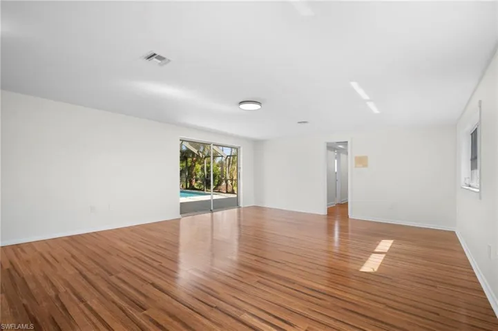 Unfurnished room featuring wood finished floors and a sunroom