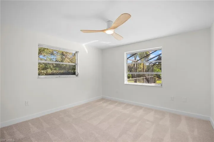 Spare room featuring light colored carpet and a ceiling fan