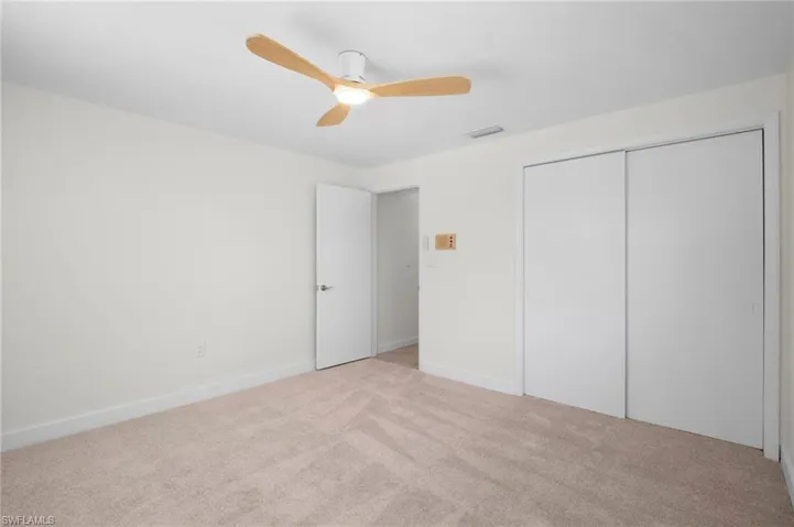 Unfurnished bedroom with carpet flooring, ceiling fan, and a closet