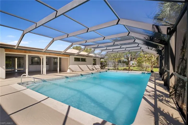 Swimming pool featuring a lanai, a sunroom, and a patio