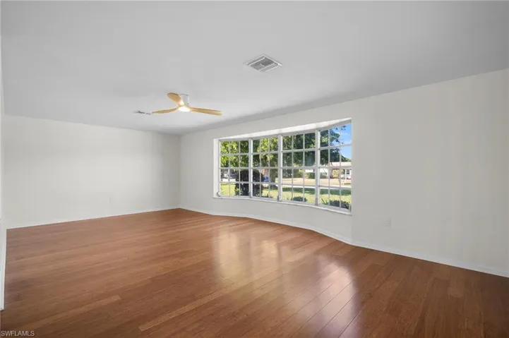 Empty room featuring hardwood / wood-style flooring and a ceiling fan