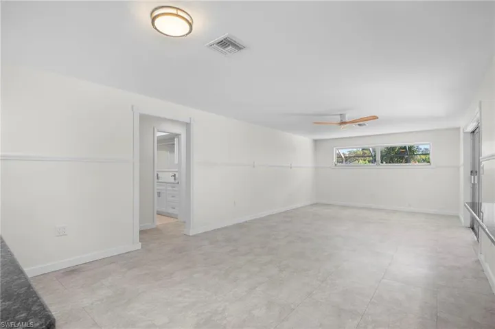 Unfurnished room with a ceiling fan and baseboards