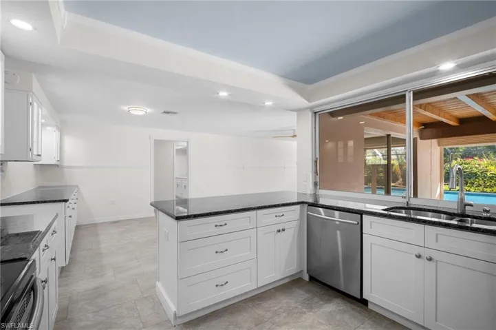 Kitchen featuring white cabinetry, dark stone counters, range with electric stovetop, dishwasher, and recessed lighting