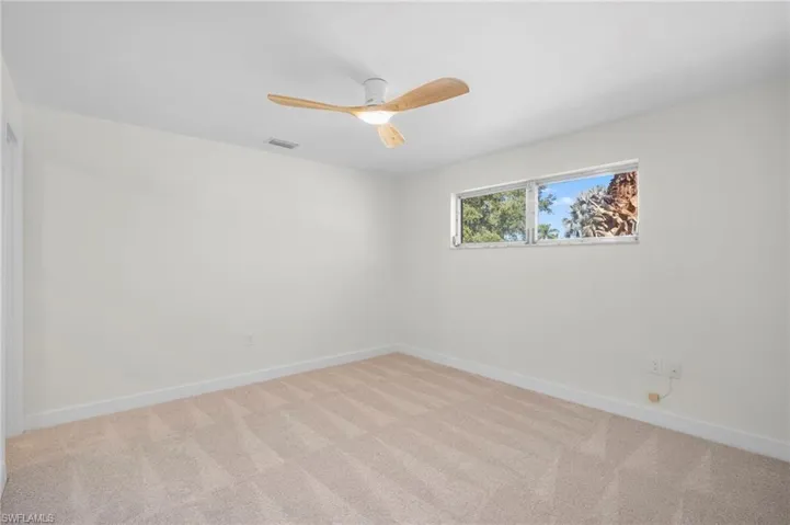 Unfurnished room featuring carpet flooring and a ceiling fan