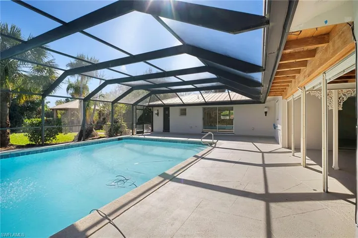Outdoor pool featuring a patio area, a sunroom, and a lanai