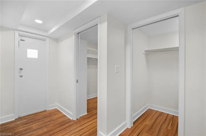 Foyer with dark wood finished floors and recessed lighting