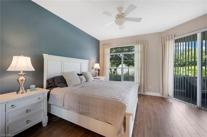 Bedroom with ceiling fan, dark hardwood / wood-style floors, and access to outside