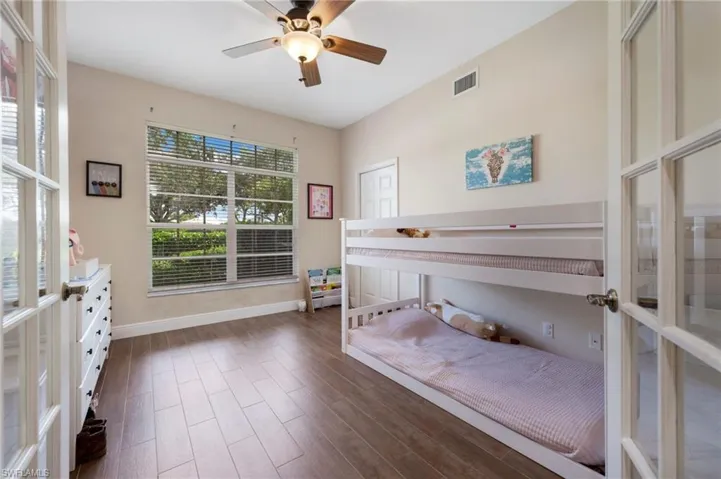 Bedroom featuring french doors, dark wood-type flooring, and ceiling fan